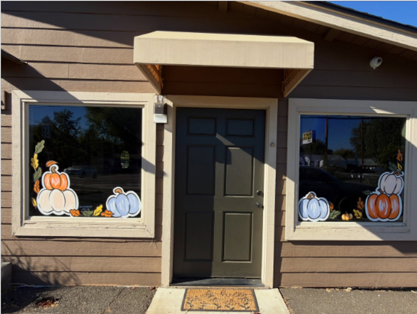 Fall pumpkin window paintings at Cedar & Sage Beauty Den by Katie Paige Art Co